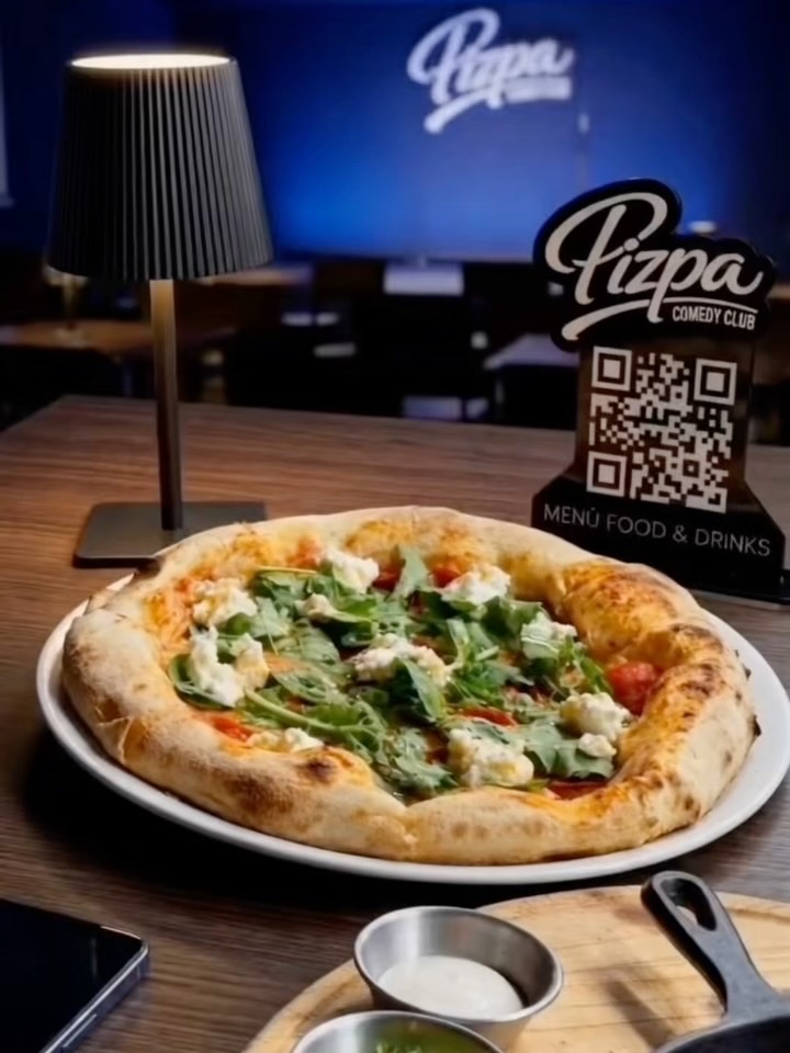 Pizpa Comedy Club: Pizza con burrata en la mesa, salón y letrero de neón